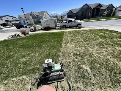 PPH crew aerating a front lawn with the truck and trailer parked at the curb