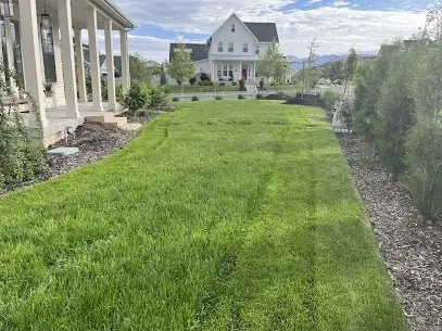 Freshly striped lawn beside a covered porch on a customer home